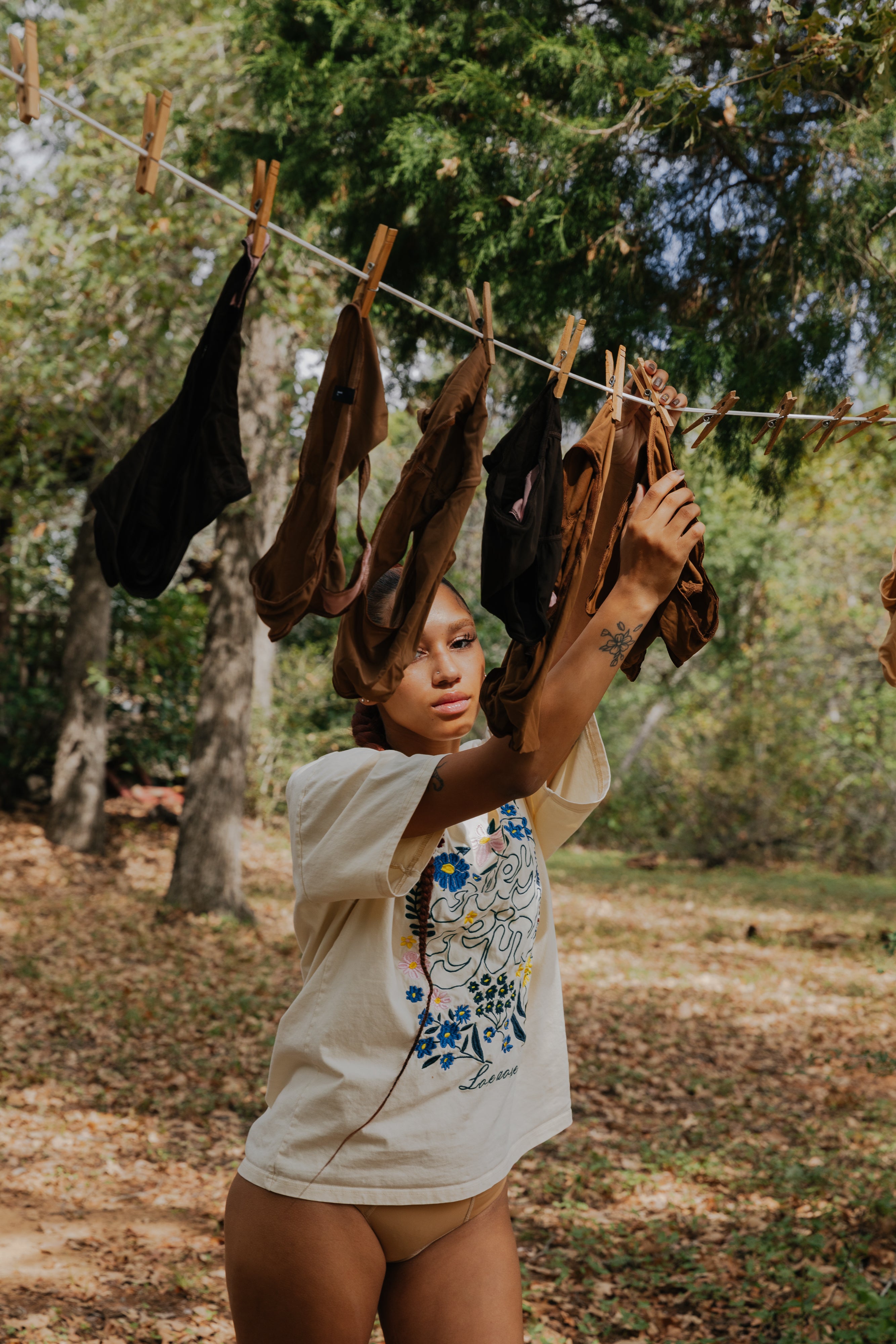 woman hanging underwear on clothing line outside